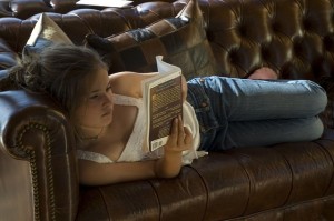 girl on leather couch reading